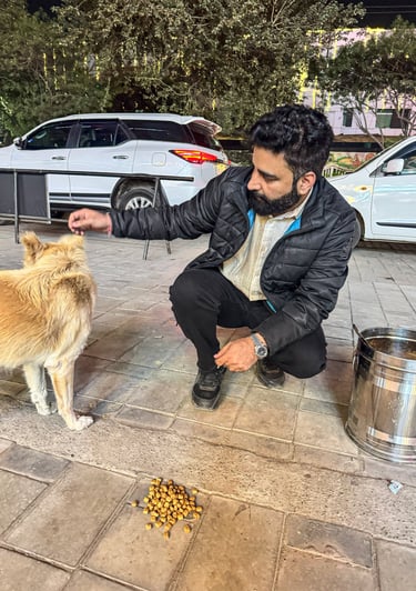 Vikash Sharma, foundation founder, feeding a stray dog during an animal welfare outreach