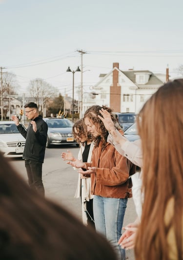 people standing in a parking lot praying