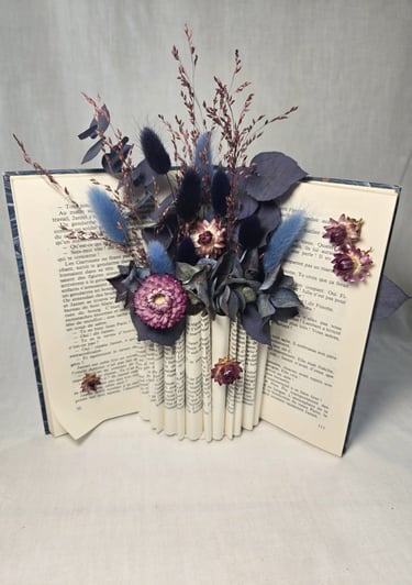 Livre ouvert avec fleurs séchées tons bleu et mauve, crée par l'Ensorce'Fleurs