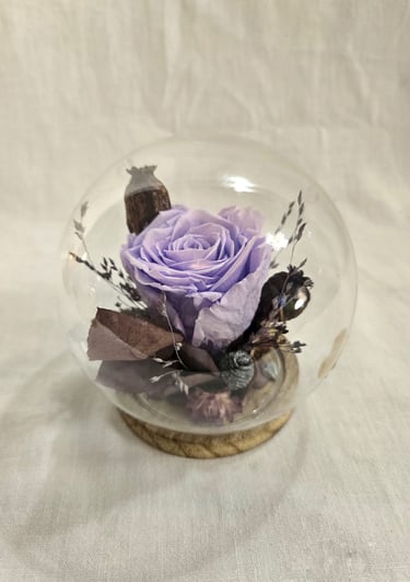 Rose éternelle et fleurs séchées, tons violet et bleu, sous cloche en verre ronde, créée par l'Ensorce'Fleurs