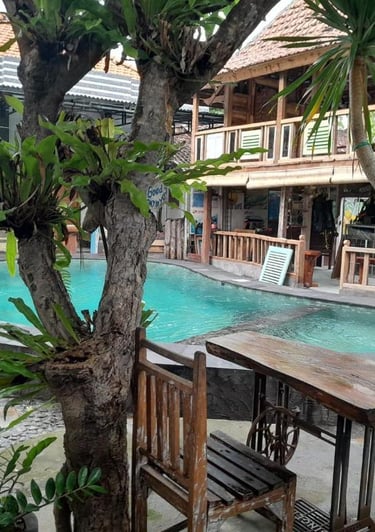 бассейн с деревянным столом и стульями вид в sunrise lodge lovina bali