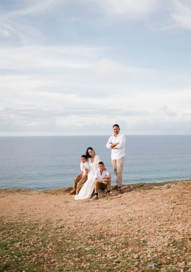 Wide cliffside view of Ayunda family enjoying the ocean backdrop at Melasti Beach Bali.