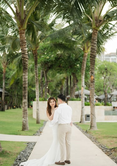 Couple standing together on a tropical garden pathway during a prewedding photoshoot at Apurva Kempinski Bali