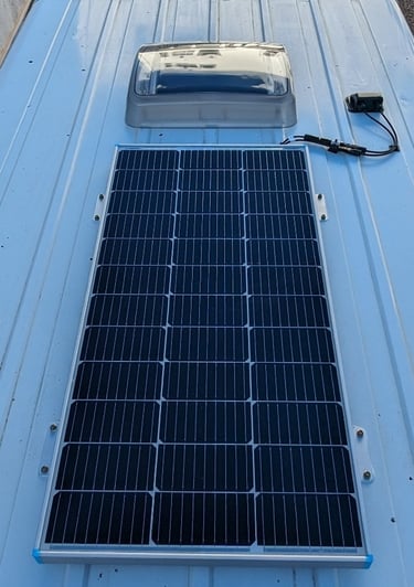 Rigid solar panel mounted to campervan roof using screws