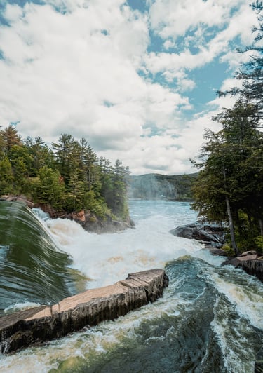 a river with a waterfall and a bridge