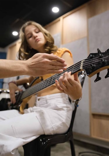 Joven estudiante aprendiendo guitarra y bajo en monochrome records