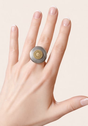 Hand with French manicure wearing a round silver and gold statement ring.