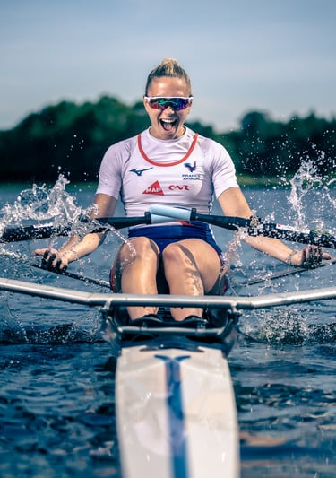 Portrait of an athlete sitting in a rowing skiff, looking to the right.