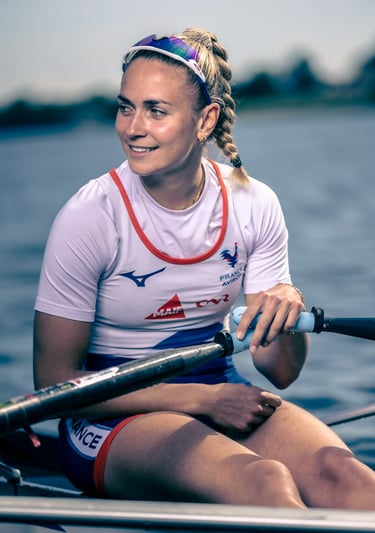 Portrait d’une athlète assise dans un skiff, regard tourné vers la droite.