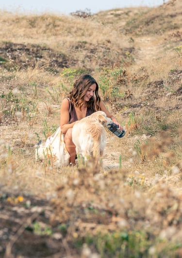 Lifestyle portrait of a woman petting her dog outdoors.