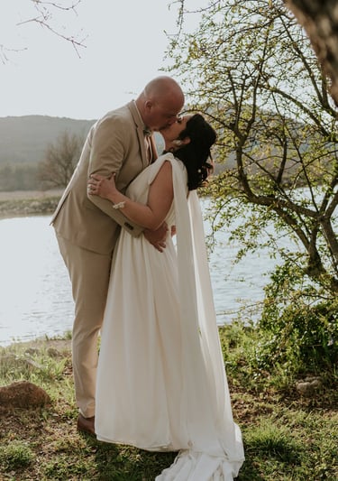 couple de mariés qui s'embrassent au bord d'un lac