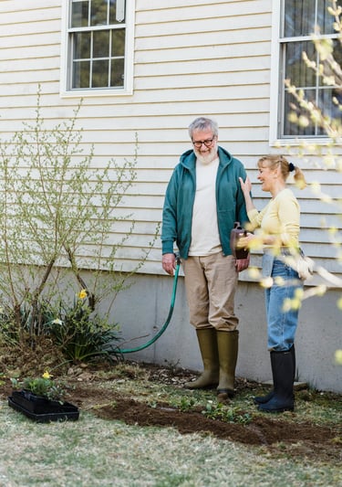 an old married couple standing in front of a house