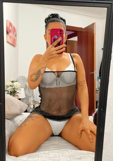 chica escort en Sabadell haciendo un selfi en una cama en ropa interior blanca y con las piernas abiertas