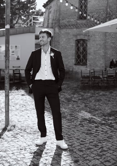 Full body portrait of a groom looking to the side.