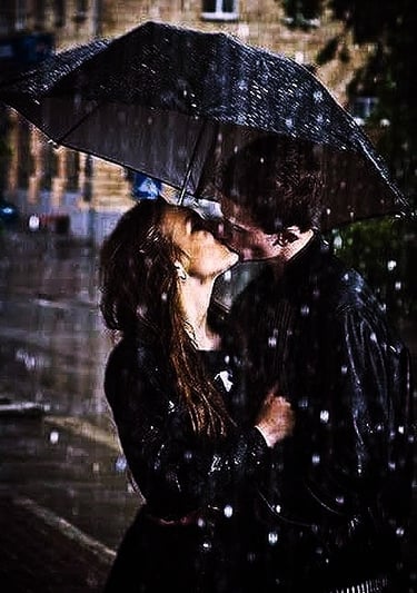Passionate kiss in rain under the umbrella