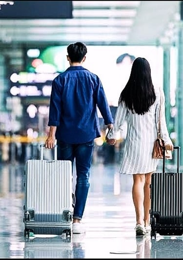 a man and woman holding hands while walking through an airport
