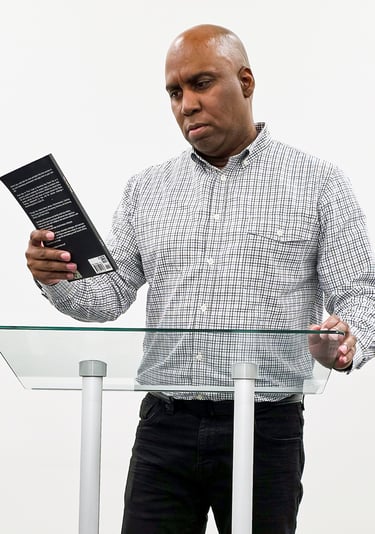 Lee A Jones standing at a podium with a book