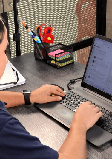 a woman sitting at a desk with a laptop computer