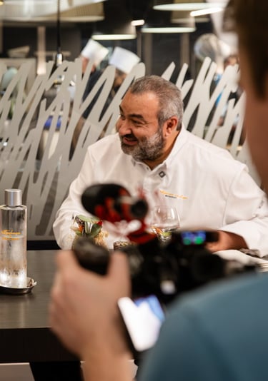 a man and woman sitting at a table with a camera