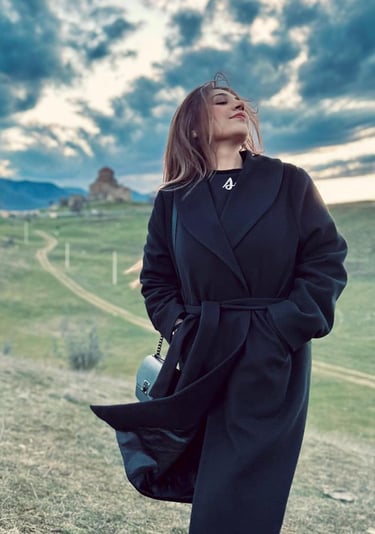 Maria Raza Sohni in a black coat and boots 
