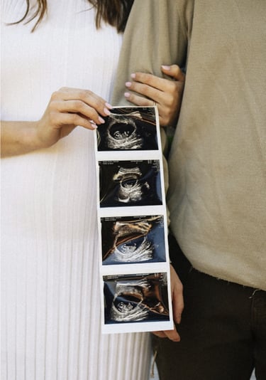 Couple holding ultrasound images representing fertility success and early pregnancy care