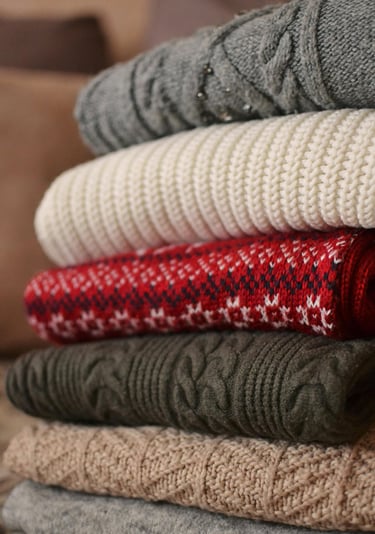 A pile of folded multicolor sweaters
