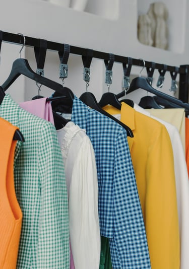 Assorted colorful women's shirts and jackets on a clothing rack