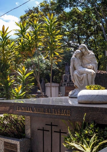 A imagem mostra uma estátua de uma estátua de uma mulher sentada em um jazigo