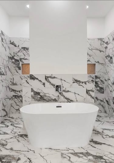 Modern soaking tub with separate vanities in primary bathroom