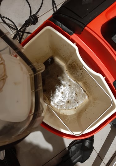 Eau très sale récupérée après nettoyage à l’injecteur-extracteur, preuve du nettoyage en profondeur.