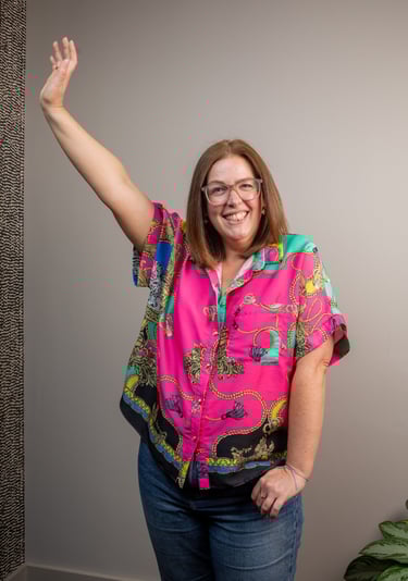 photo of gabi, founder of the leopard mind, smiling with her right arm in the air