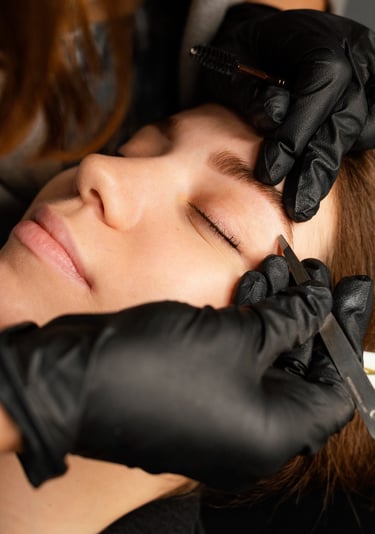 Artista de cejas profesional que utiliza pinzas para dar forma y arreglar las cejas.