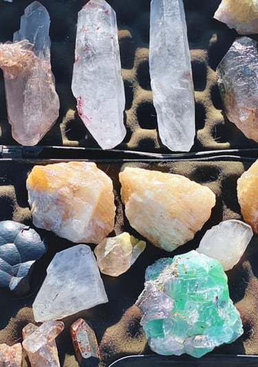 Colección de cristales y minerales en bruto que incluye puntas de cuarzo transparente, amatista.