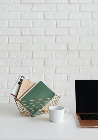 a laptop computer sitting on a desk with a cup of coffee