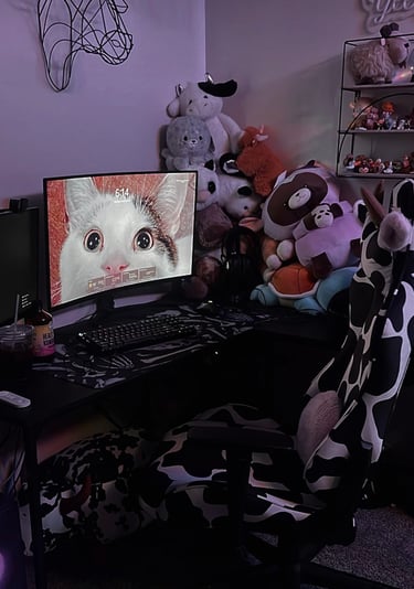 a computer desk with a computer monitor and a cat