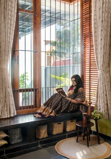 a woman sitting on a bench in a window