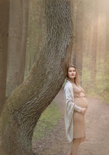 Nėštukė pozuoja prie įdomios formo medžio Varnikų pažintiniame take 