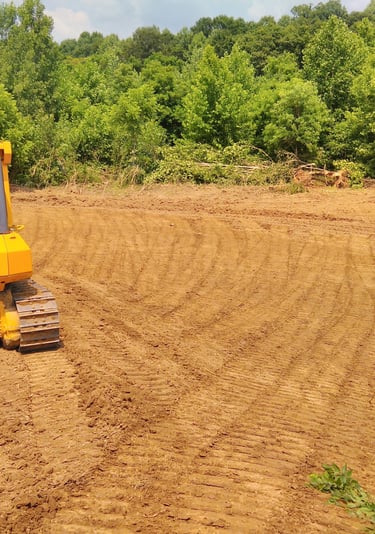 a tractor with a bulldozer in the middle of a field