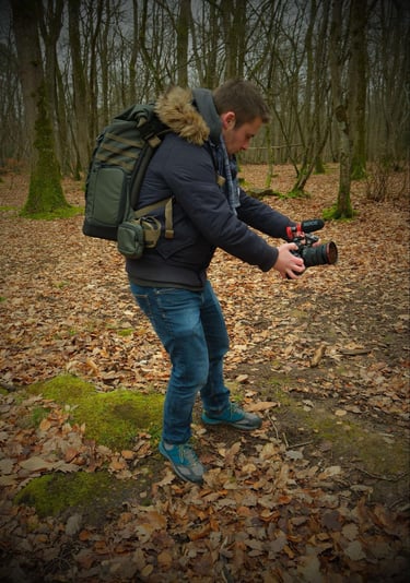 a man in a blue jacket and jeans is taking a picture of a camera