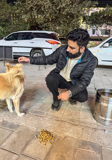 Vikash Sharma, foundation founder, feeding a stray dog during an animal welfare outreach
