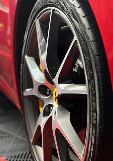 raudonas ferrari automobilis su geltonu ratu ir juoda padanga