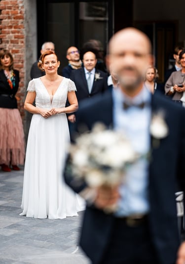 Une femme en robe de mariée blanche derrière son mari