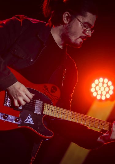 Dimitri jouant avec une telecaster fender rouge éclairé par un spot rouge au concert de rush on mars