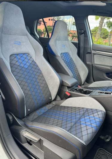 Volkswagen Golf R interior featuring gray alcantara bucket seats with blue tartan plaid patterns.