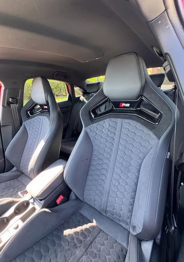 Audi RS sports seats with black honeycomb stitching and Alcantara upholstery in a luxury car interior.