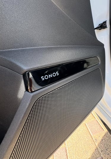 A Sonos premium car audio speaker system integrated into a black vehicle door panel.