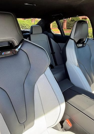 Luxury BMW M5 interior featuring two-tone grey leather sport bucket seats with M series branding.