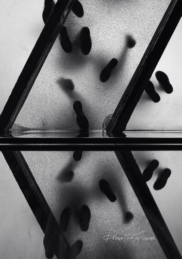 Beneath the fractured glow of a glass walkway, footsteps divide into two worlds—one real, one mirror
