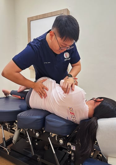 Chiropractor aligning patient’s spine using side posture technique at Sinisana Chiropractic.