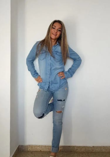 Sandy votre assistante debout contre un mur blanc